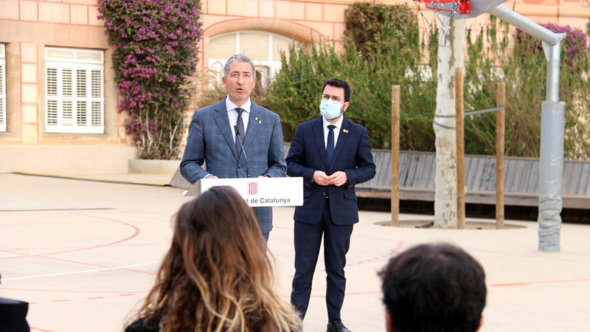 El conseller de Educació, Josep Gonzàlez-Cambray, en rueda de prensa, al presidente de la Generalitat, Pere Aragonès, escuchándolo.