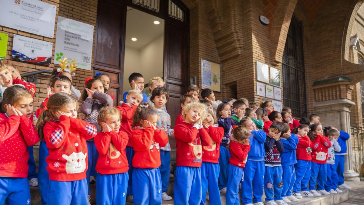 Los alumnos cantan en las escaleras de la puerta de la escuela.