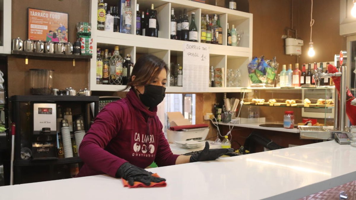 Imagen de archivo de una camarera limpiando la barra del bar Ca la Meri de Tarragona.