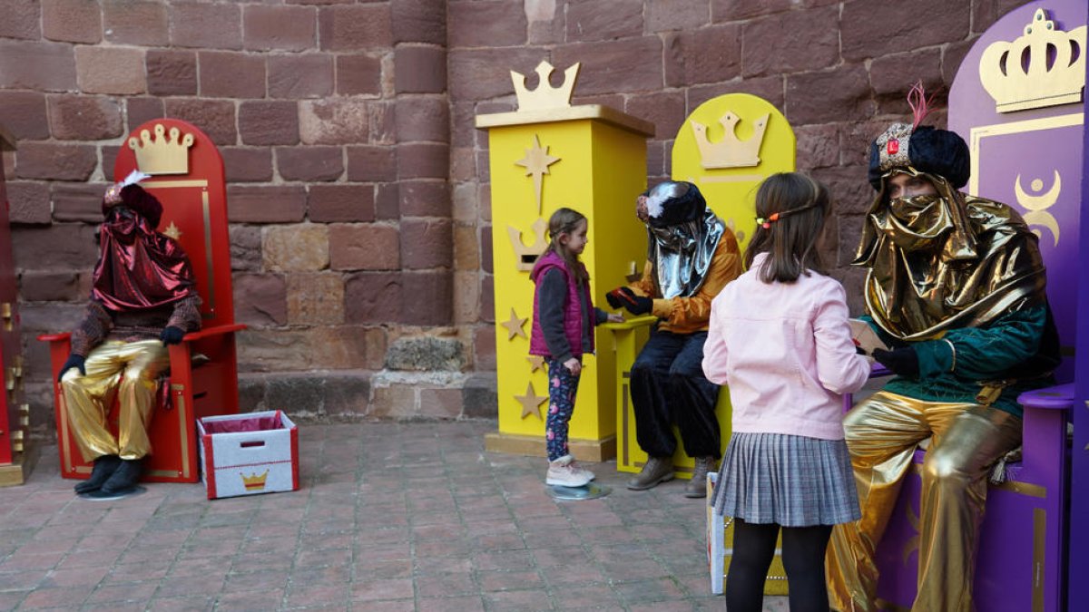 Diversos nens lliurans les seves cartes als emissaris reials.