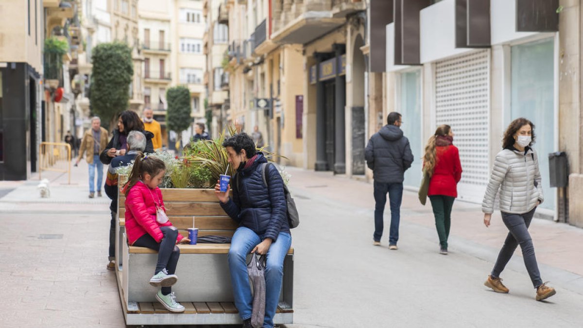 Elena López asseguda amb la seva filla a un dels 'parklets' mentre prenien un batut de Xixona.