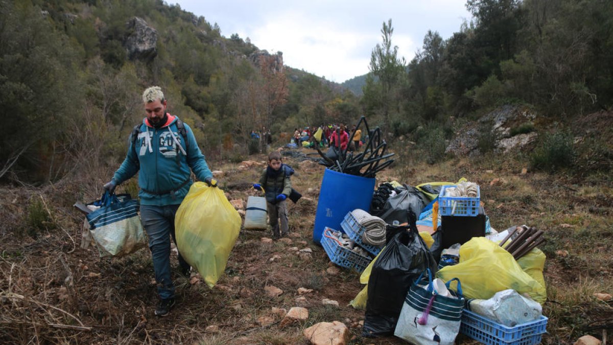 Dos voluntarios retiran desechos de una de las plantaciones.