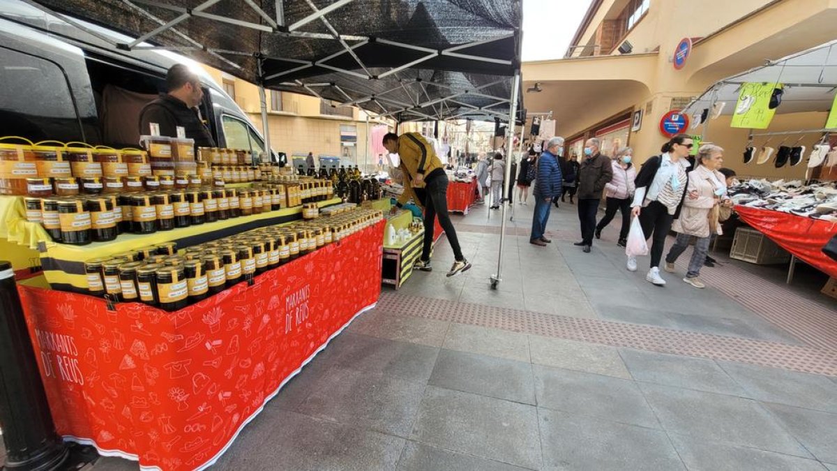 Las paradas llevan falda roja con un estampado de la diversidad de productos que se venden en los mercados.