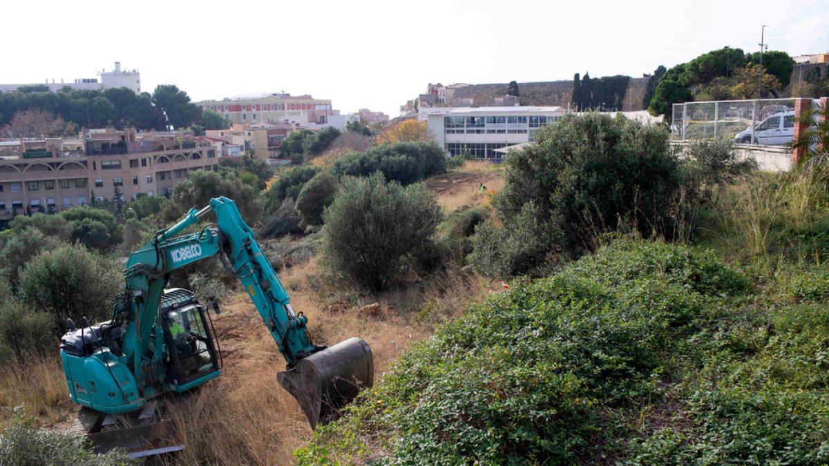 Una màquina excavadora treballant en les obres d'ampliació de l'aparcament municipal de Torroja.