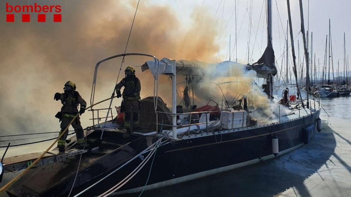 Los bomberos trabajan en el barco incendiado.