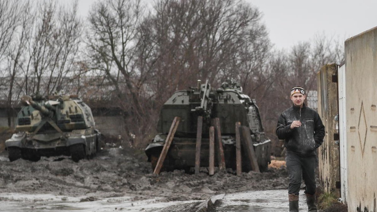 Un hombre delante de tanques rusos en Ucrania.