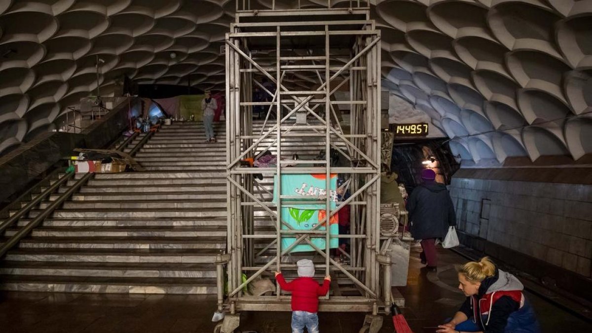 Una mare juga amb la seva filla dins una estació de metro usada com a refugi, a Kharkov