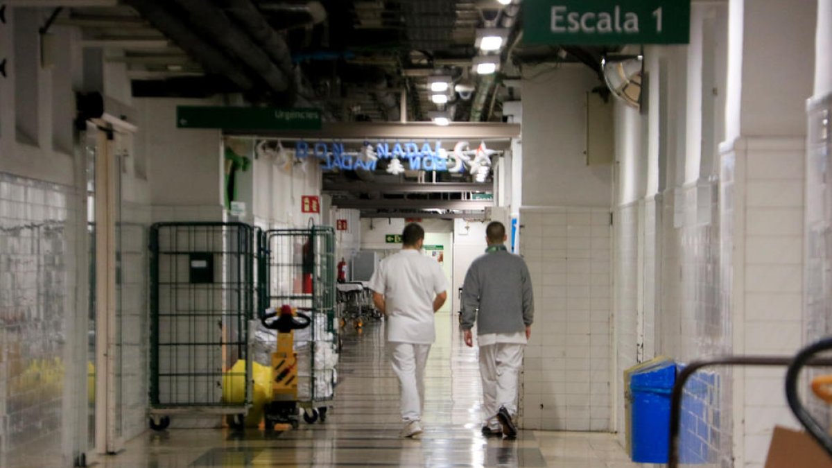 Dos sanitaris caminant per un dels passadissos de l'Hospital Clínic de Barcelona.