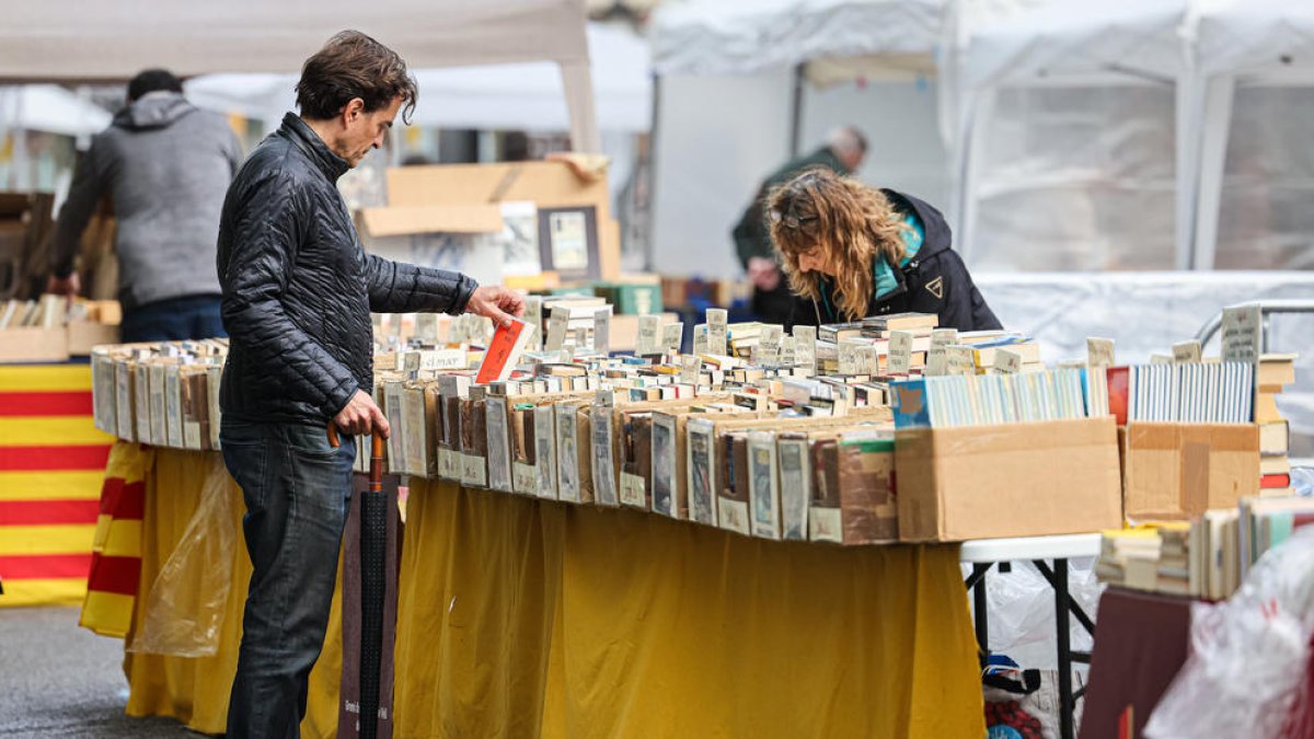 Un comprador mirant els llibres d'una paradeta.