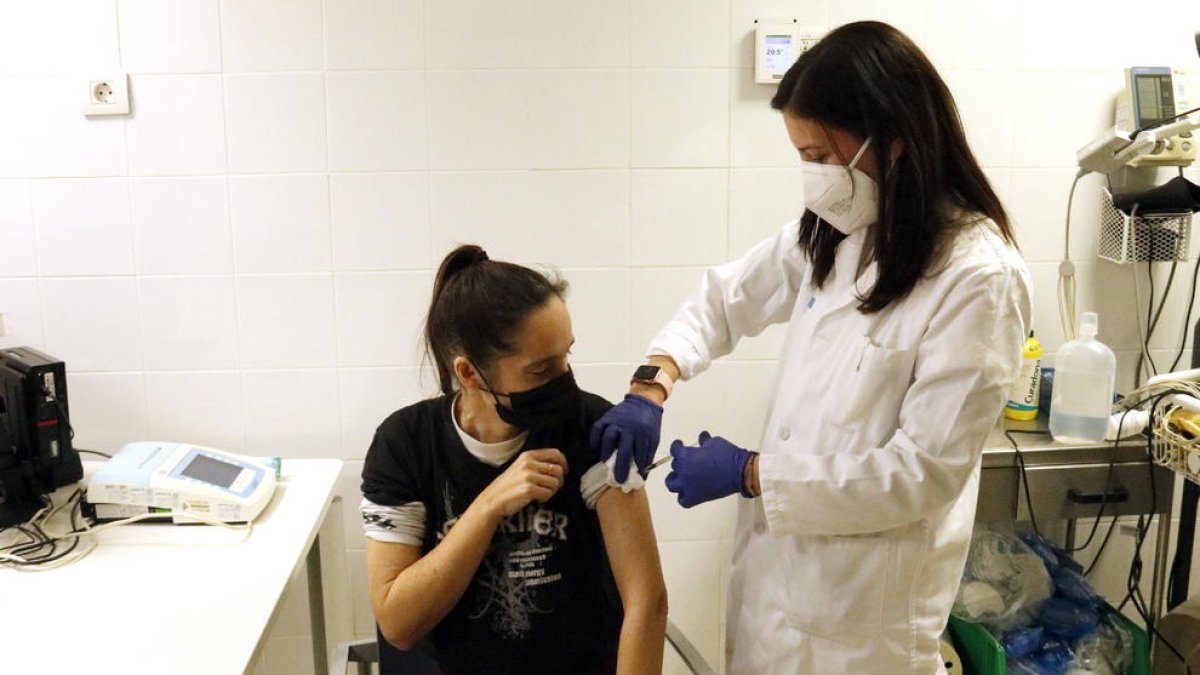 Una dona es vacuna contra la covid-19 i la grip al CAP Primer de Maig de Lleida.