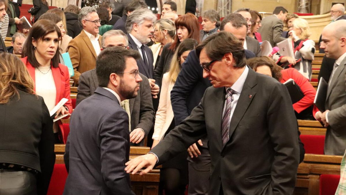 El líder del PSC, Salvador Illa, toca el brazo del presidente de la Generalitat, Pere Aragonès.