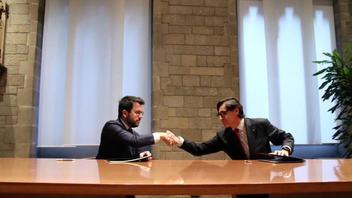 Aragonès i Illa es donen la mà després de signar l'acord per l'aprovació dels pressupostos del Govern del 2023.