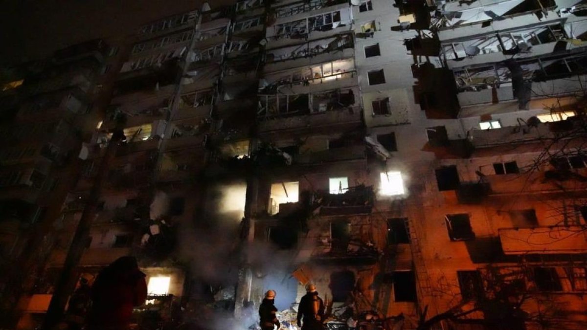 Dos bombers miren les destrosses provocades per un atac rus contra un bloc de 10 plantes de pisos a Kíev durant la matinada del 25 de febrer.
