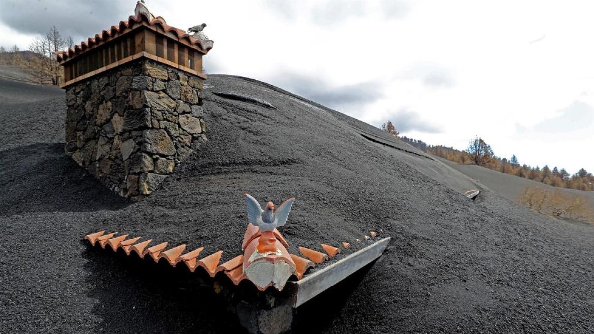 Una chimenea y un tejado sobresaliendo de la lava.