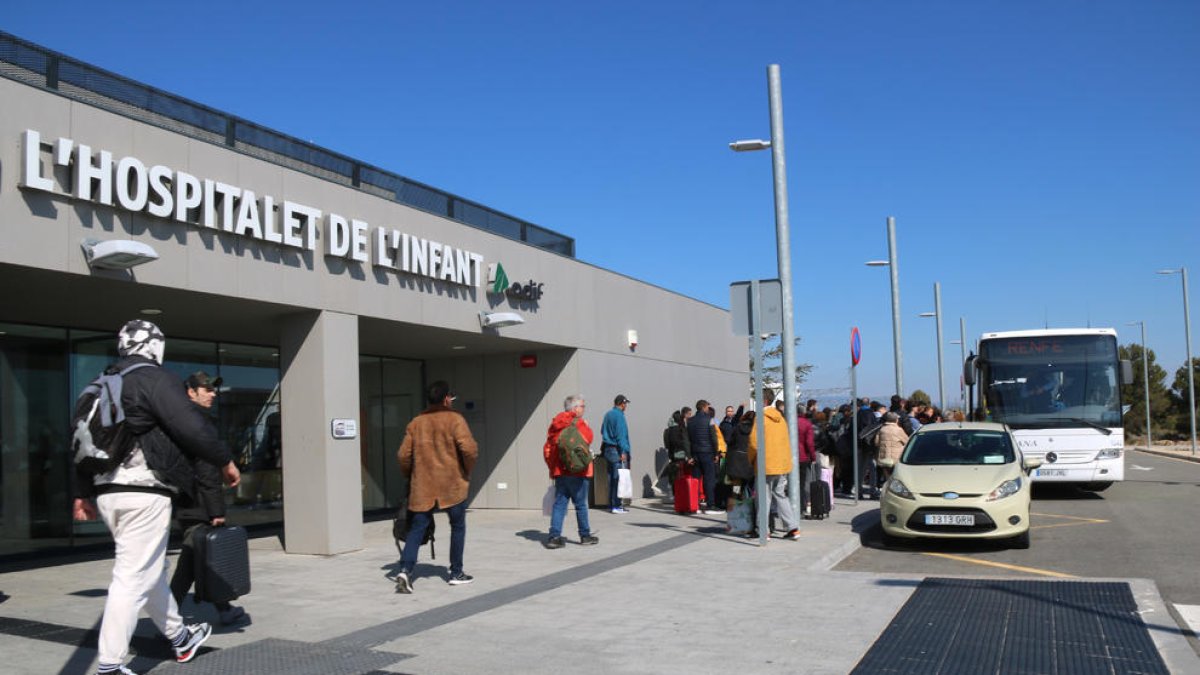 Passatgers afectats per l'avaria a la catenària pujant a un autobús.