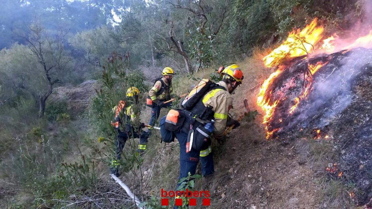 Bombers treballant en l'incendi.