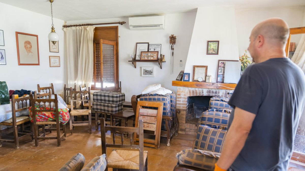 Un vecino de Altafulla limpiando su casa e intentando salvar los muebles del comedor, donde agua durante un temporal.