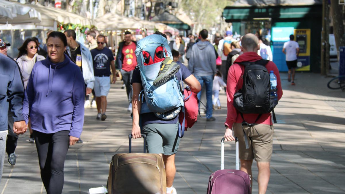 Turistes amb maletes per la Rambla a Barcelona.