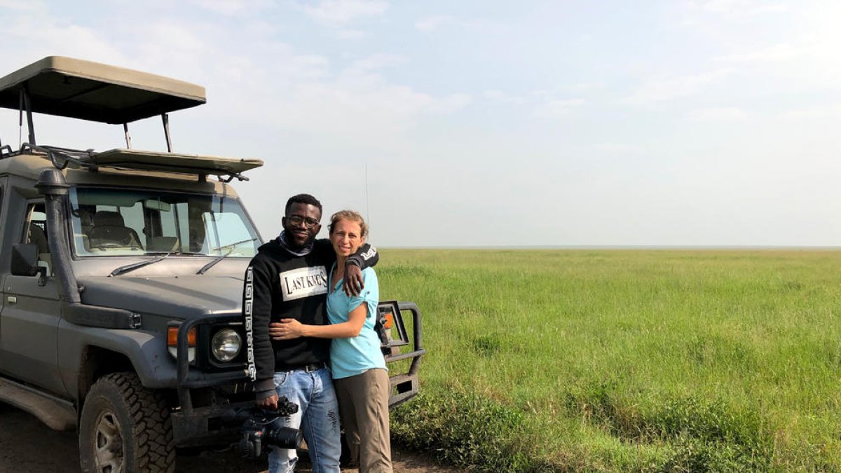 La falda Pilar Millan junto a su marido Henry Mwakajumba frente a un vehículos con los que realizan rutas por Tanzania.