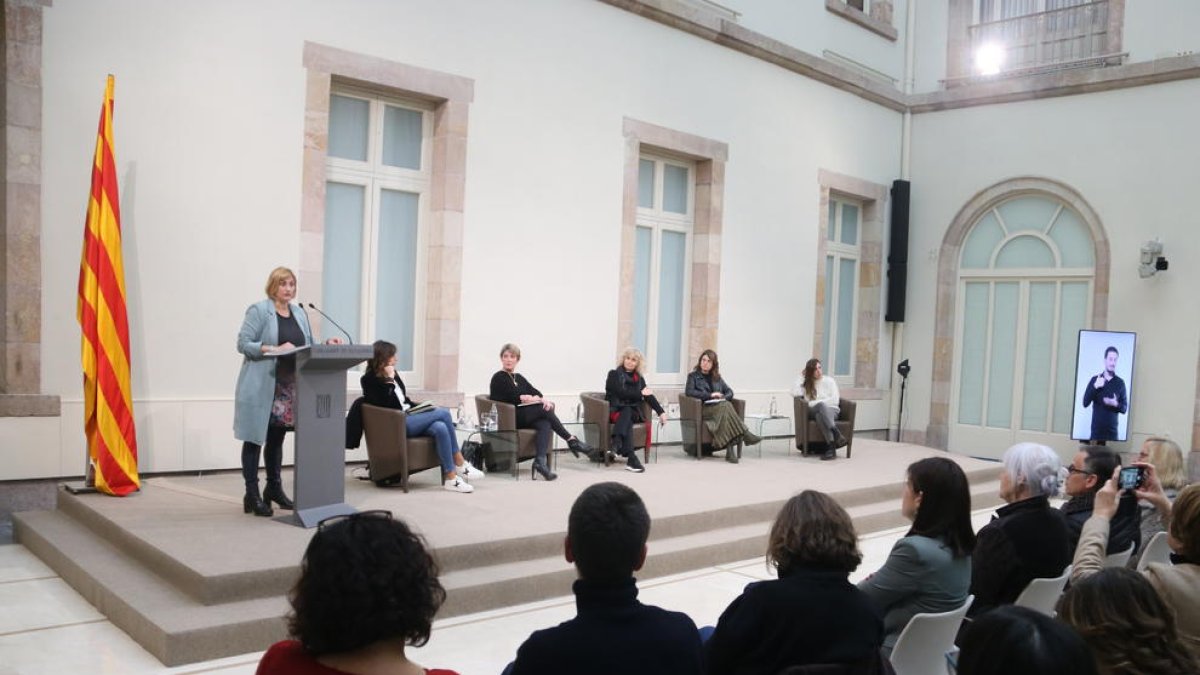 La vicepresidenta primera en funcions de presidenta del Parlament, Alba Vergés, durant l'acte, acompanyada de diverses periodistes.