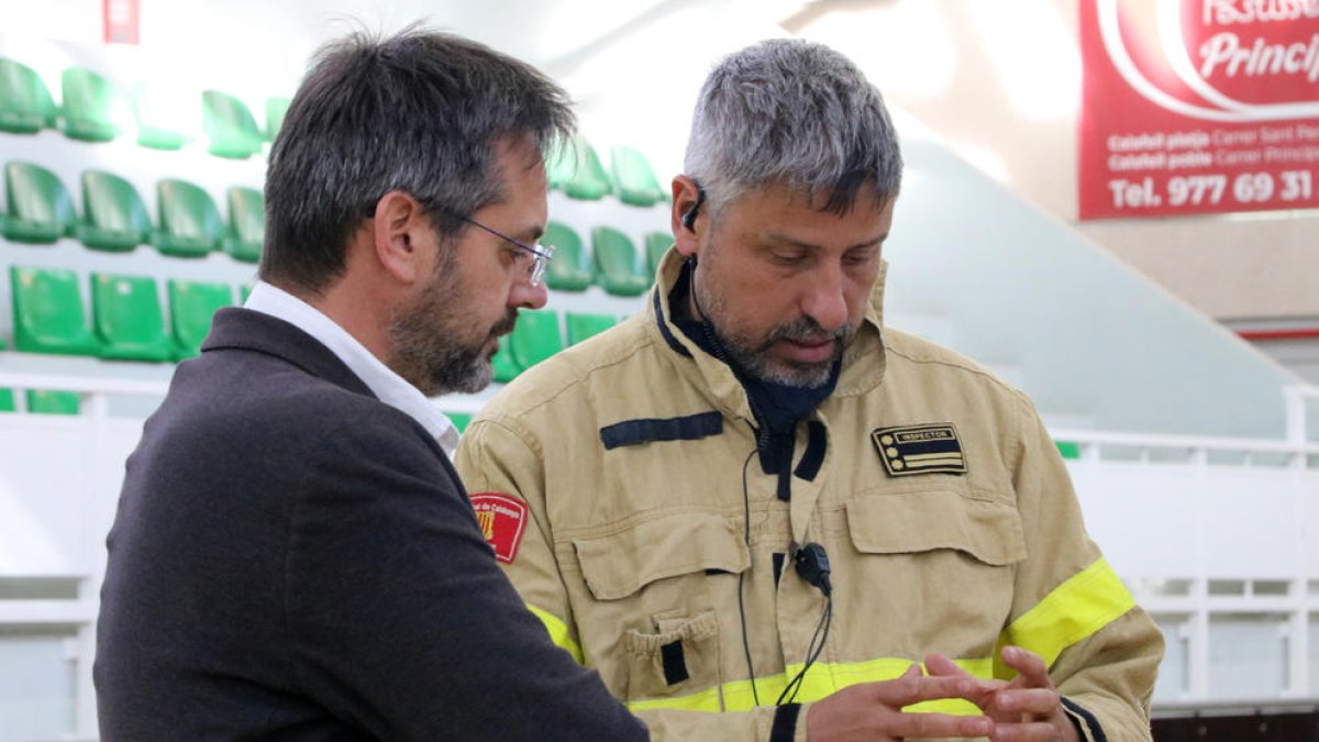 El inspector de Bombers, Miquel López, hablando con el delegado del Govern del Penedès, David Alquezar, en el centro de mando del incendio.