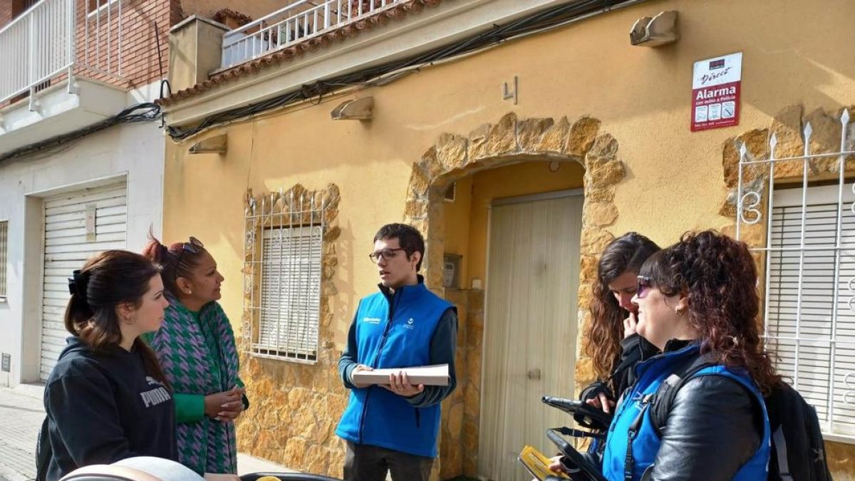 Dos dels voluntaris durant la jornada d'ahir fent una visita als veïns de la Plana.