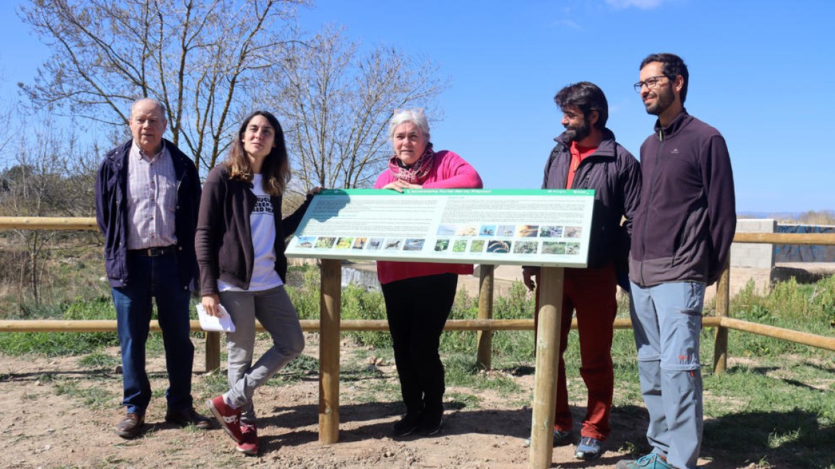 Les regidores de Medi Ambient i Districtes de Tarragona, Eva Minguell i Paula Varas, així com l'equip de l'Associació Aurora al costat d'un cartell informatiu sobre la biodiversitat rescolsa de Sant Salvador.