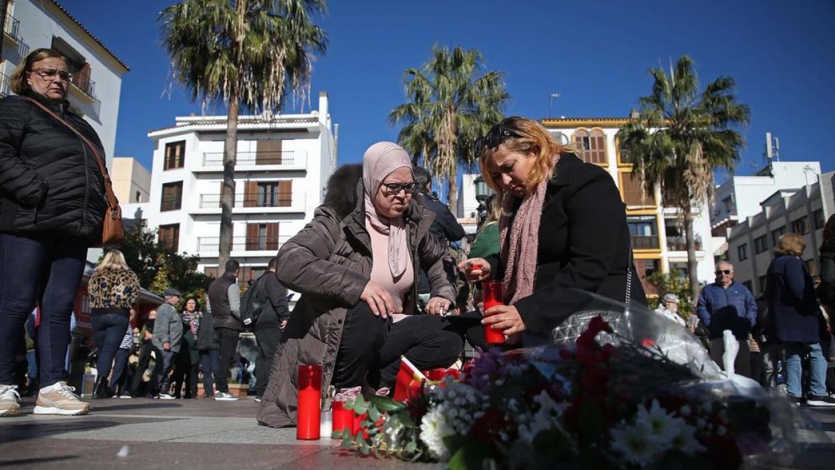 Dues dones col·loquen una espelma al lloc on van assassinar el sagristà d'Algesires.