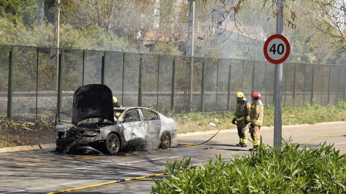 El vehicle cremat al costat de la via.