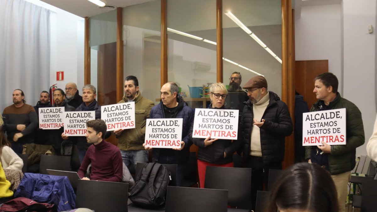 Els treballadors de la brossa amb pancartes durant el plenari municipal a la sala d'actes de l'Institut Municipal d'Educació.