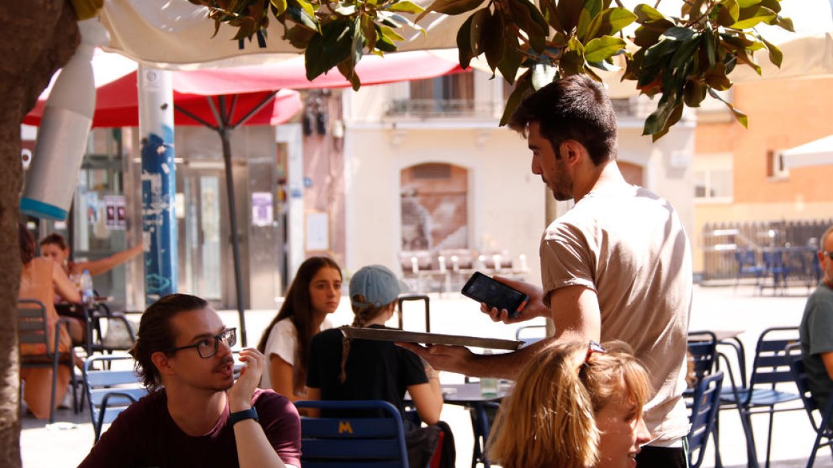 Un cambrer a la terrassa del bar Sol Soler de Gràcia.