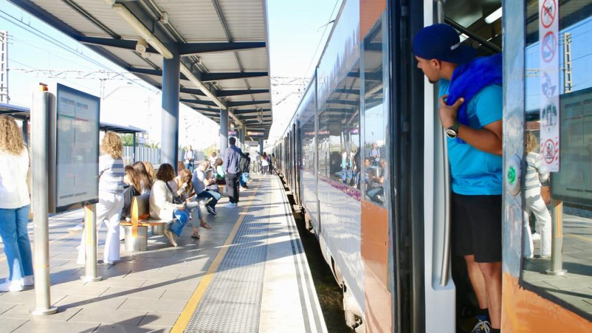 Un usuari treu el cap en un tren de Rodalies aturat a l'estació de Gavà.