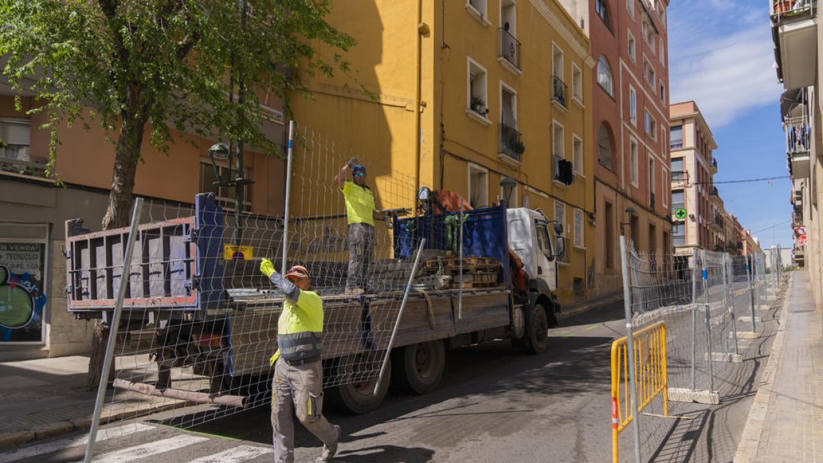 Els obrers ja han començat a posar tanques metàl·liques a les dues voreres del carrer.