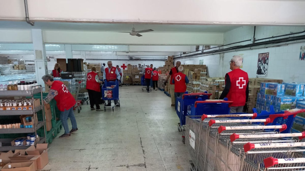 Diversos voluntaris de Creu Roja empaquetant productes.