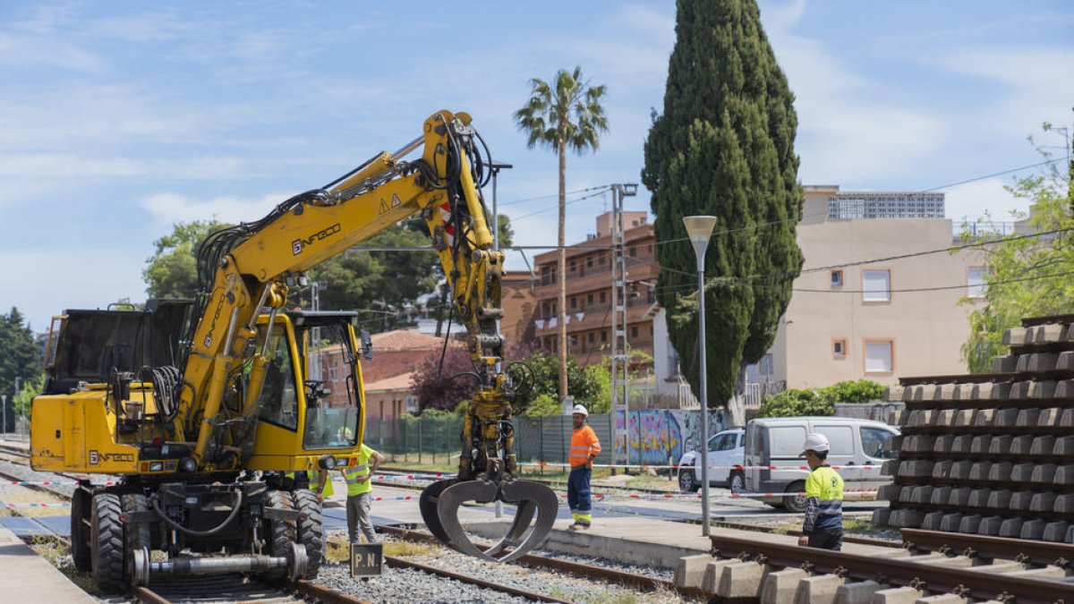 La grua amuntegant les travesses ahir al matí, en la part del traçat pròxim a l'antiga estació.