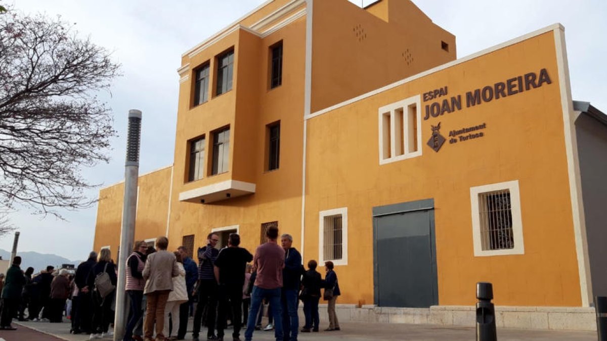 Desenes de persones esperen a l'entrada del nou Espai Joan Moreira de Ferreries, a Tortosa.