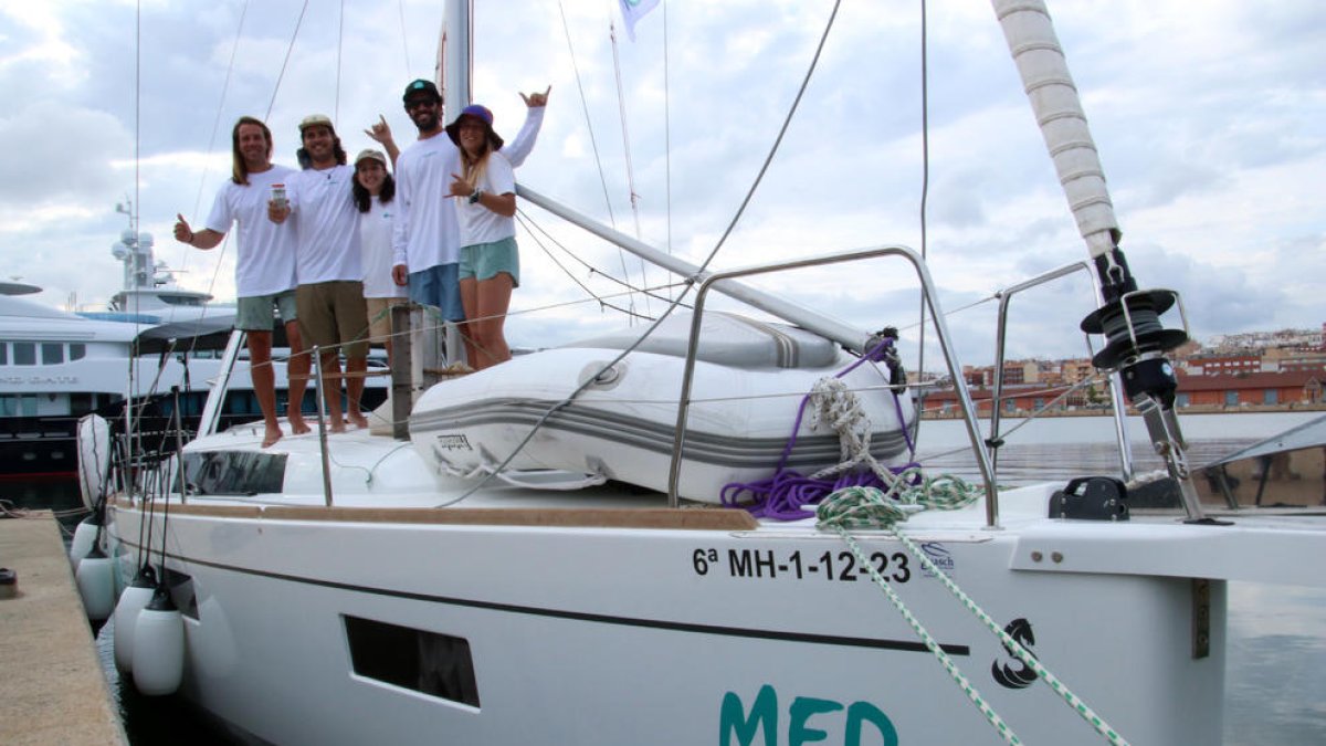 Miembros de la expedición Good Karma Projects al velero en el puerto de Tarragona.