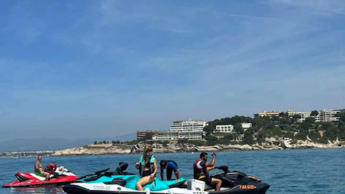 Uns usuaris fent ús de les seves motos aquàtiques particulars a una platja de Tarragona.