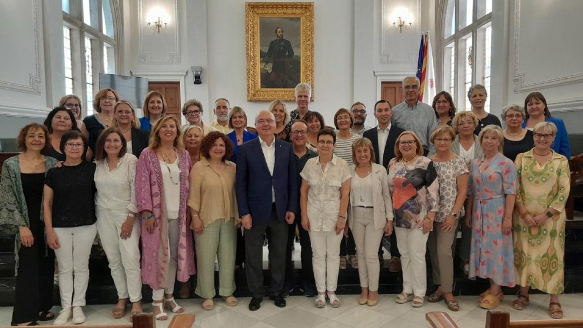 Els professors homenatjats amb l'alcalde en funcions, Carles Pellicer, al Saló de Plens.