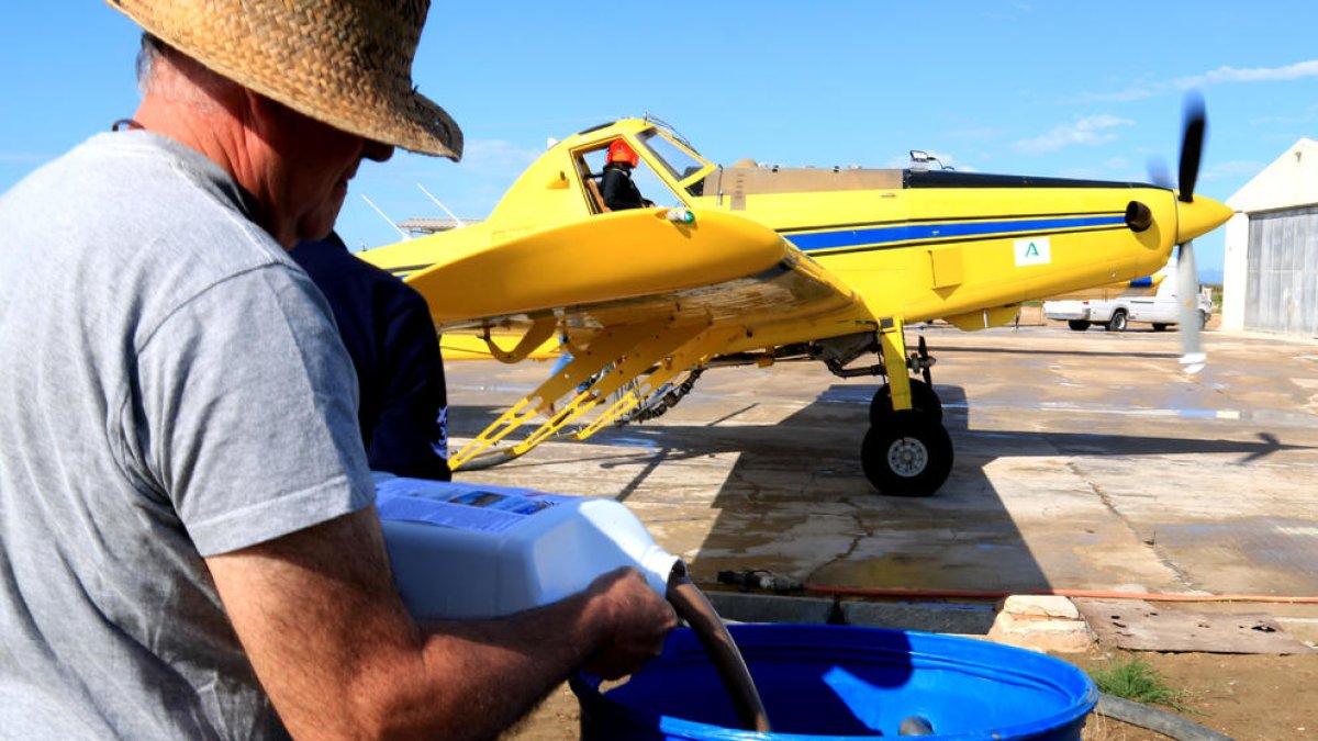 Los técnicos preparen el BTI para cargar el avión que realizan los tratamientos contra los mosquitos en el Delta.