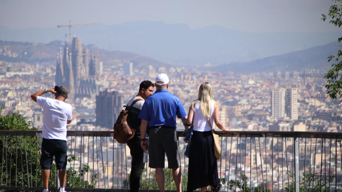 Unos turistas contemplan las vistas de Barcelona desde Montjuic.