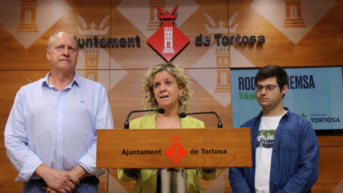 La portaveu de Junts a l'Ajuntament de Tortosa, Meritxell Roigé, compareix a la sala de premsa de l'Ajuntament flanquejada pels regidors Jordi Sorolla i Òscar Ologaray.