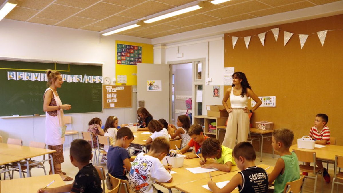 Imatge d'arxiu d'un grup d'infants fent activitats a l'aula amb llapis de colors.