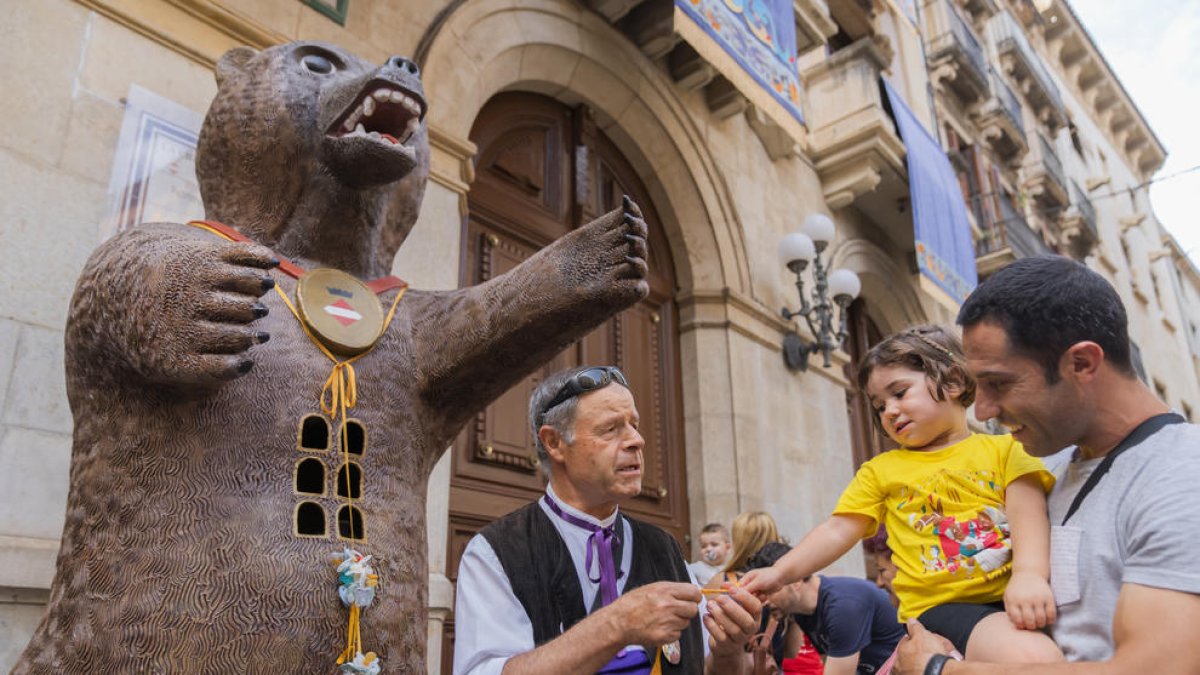 Un infant de Valls engalanant l'Os amb l'entrega dels xumets.