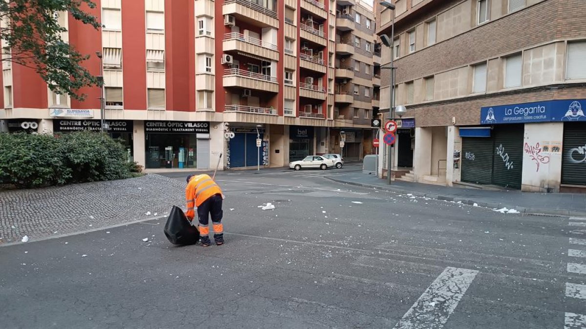 Un operari de la neteja retirant el porexpan que han llençat pel centre de Tarragona.