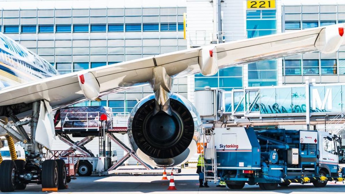 Imatge d'un treballador al costat d'un gran motor d'avió.