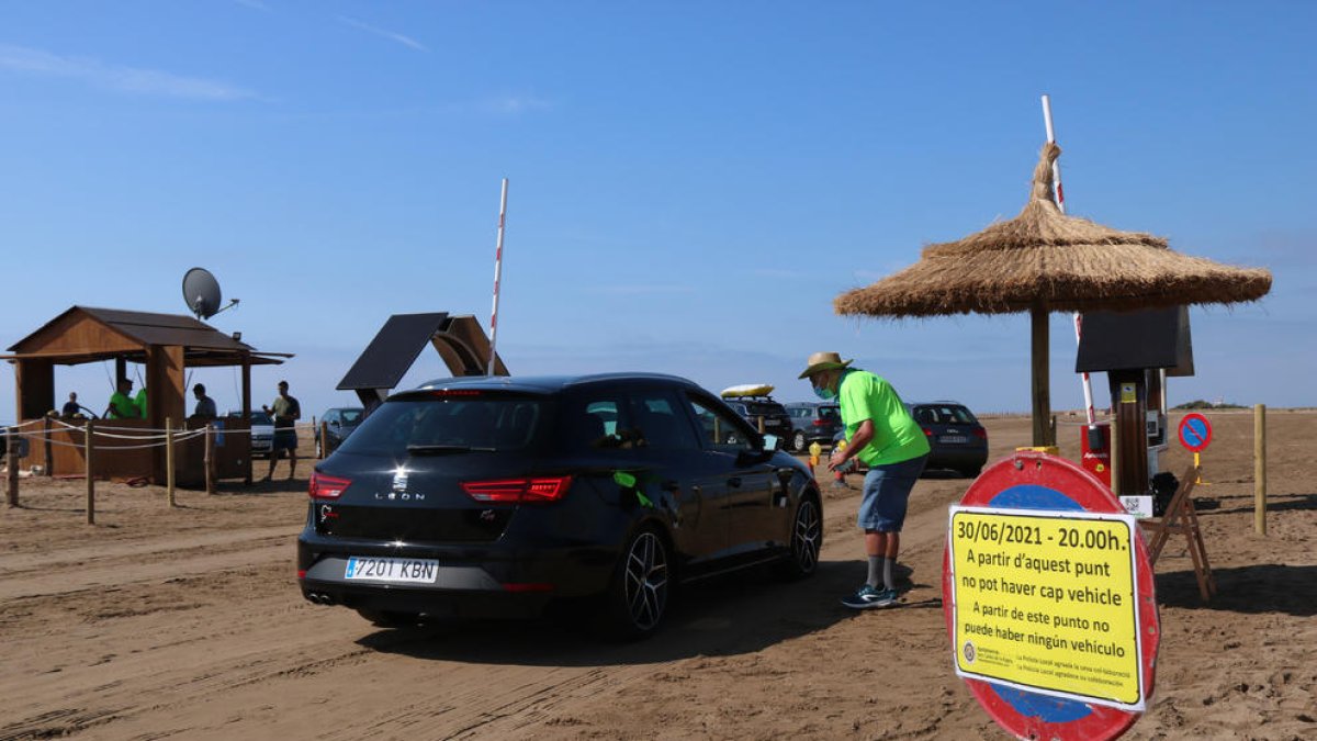 Pla general d'un agent cívic i d'un vehicle accedint a la platja del Trabucador en el primer dissabte de la nova regulació.