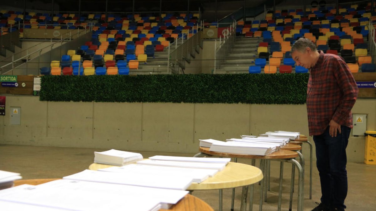 Un hombre mirando las papeletas en la Tarraco Arena por las elecciones del 28-M.