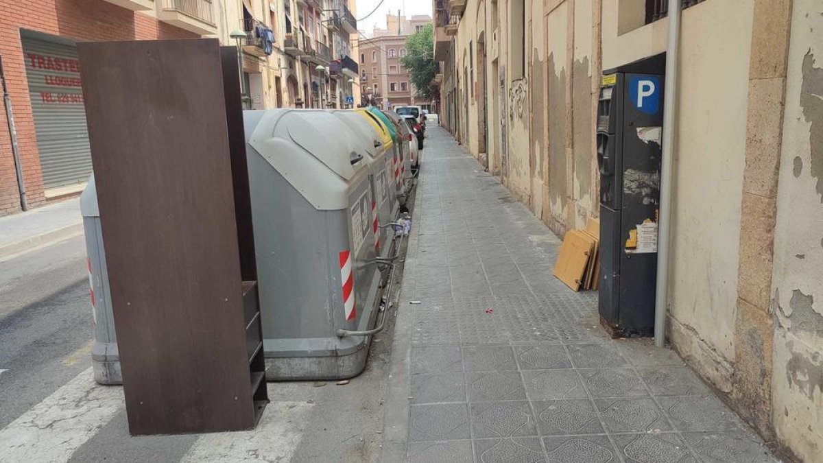 Imatges d'ahir a diferents punts del barri del Port, on es poden observar diversos trastos i mobles abandonats al costat d'illes de contenidors.