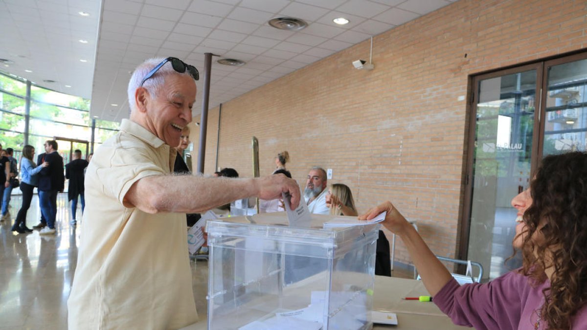 Un home diposita el seu vot en una de les meses constituïdes al Palau Firal de Tarragona.